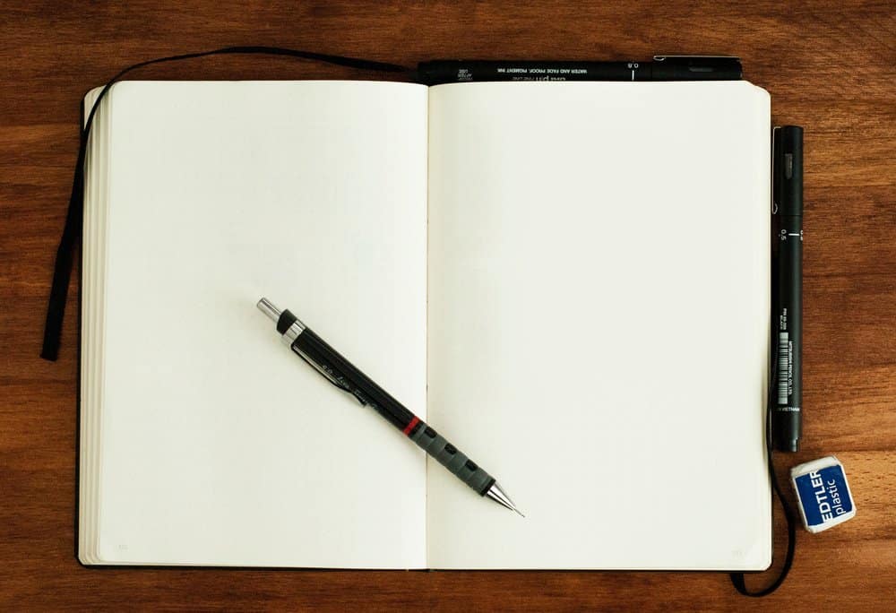 A pen and notebook on a table Description automatically generated