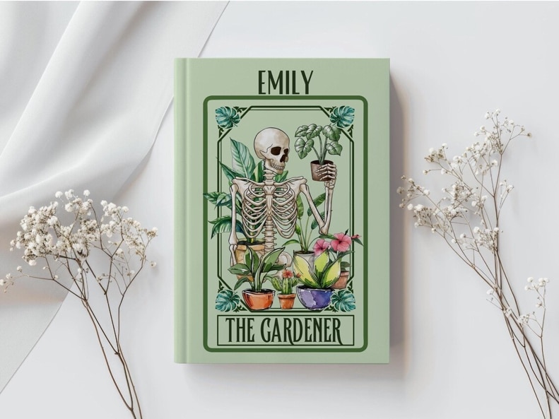 May include: A green book with the name 'Emily' printed in white on the front cover. The book features a skeleton holding a potted plant in front of a green background with other plants and the words 'The Gardener' printed in white at the bottom.