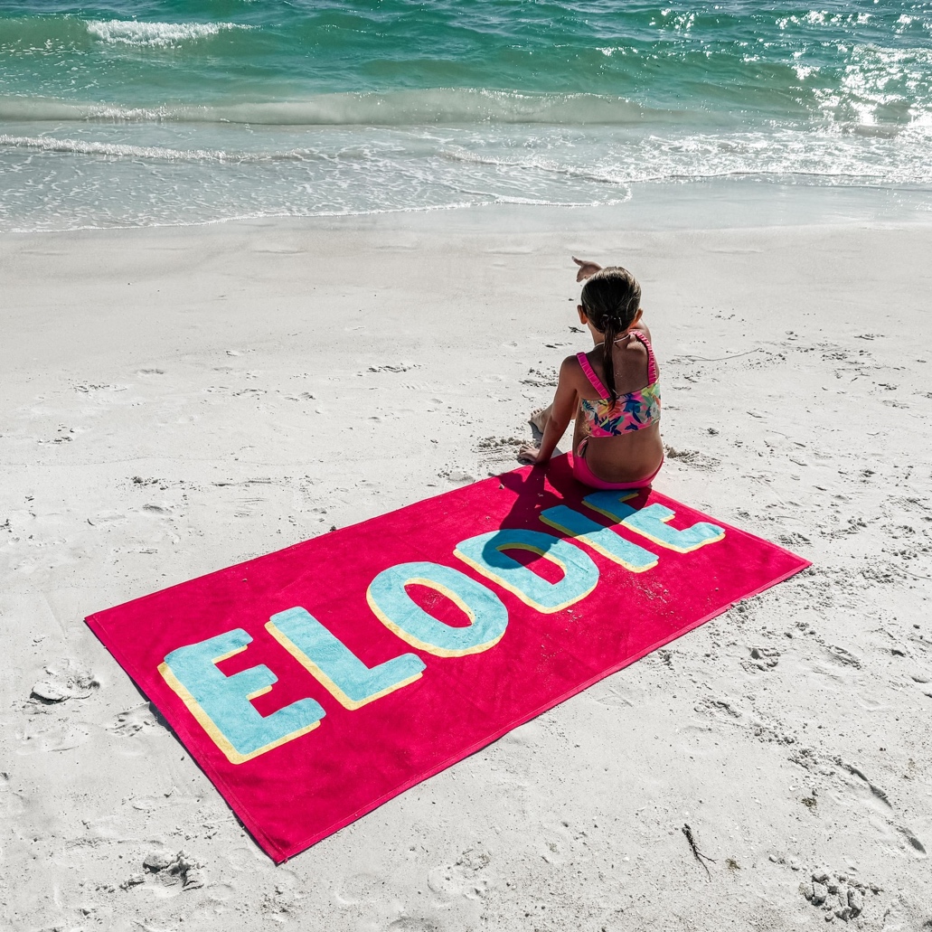 A child sitting on a beach towel Description automatically generated