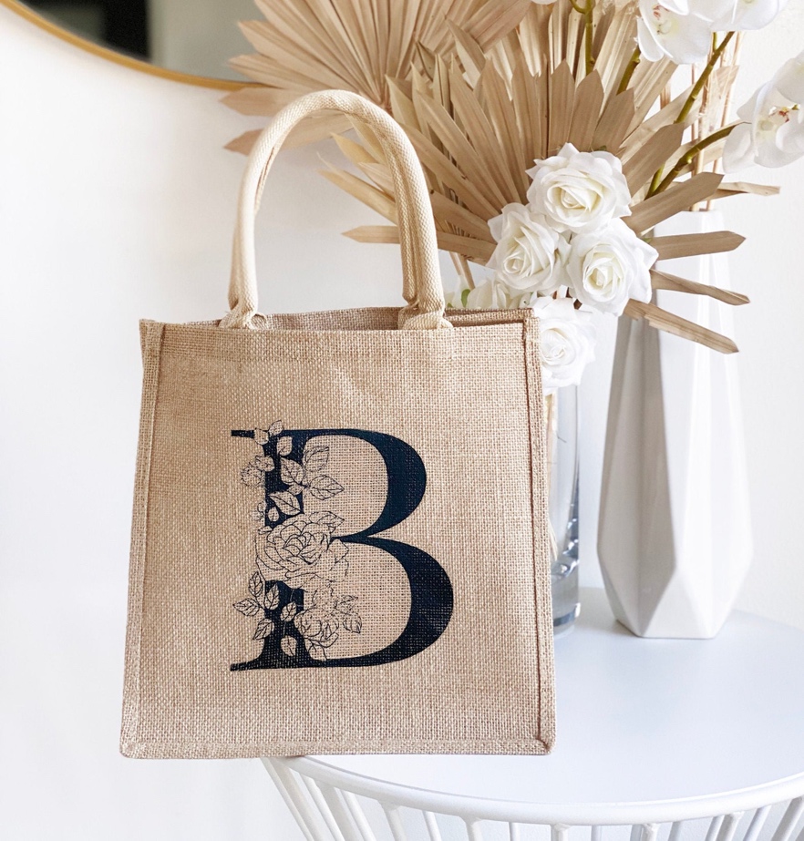 A personalized jute tote bag featuring a floral monogram.