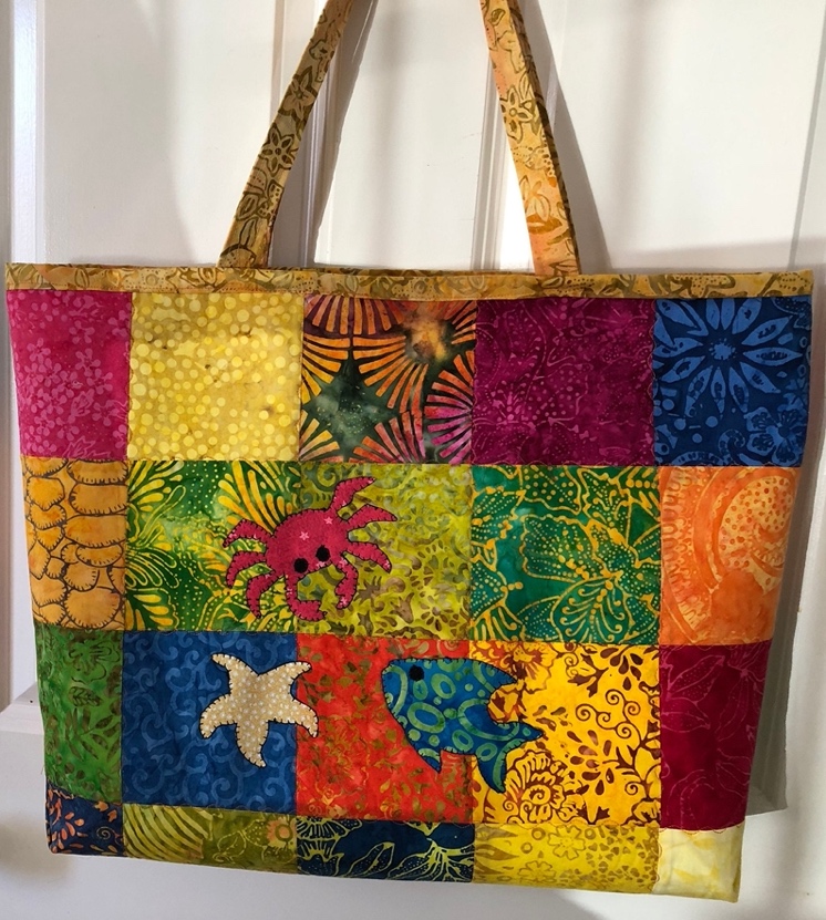 A vibrant, patchwork tote bag featuring sea life designs
