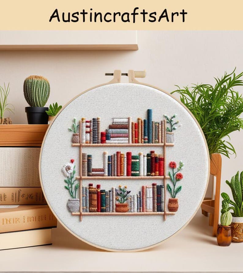 May include: Embroidered hoop art featuring a bookshelf design. The artwork showcases a three-tiered bookshelf filled with colorful books, potted plants, and the text "AustincraftsArt" at the top. The embroidery is set in a wooden hoop.