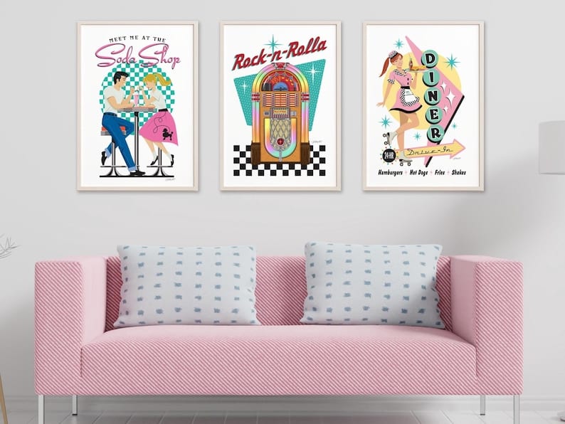 May include: Three framed retro-style prints. The first depicts a couple at a soda shop, the second a jukebox, and the third a diner scene. Each print features vibrant colors and vintage typography, evoking a classic 1950s aesthetic.